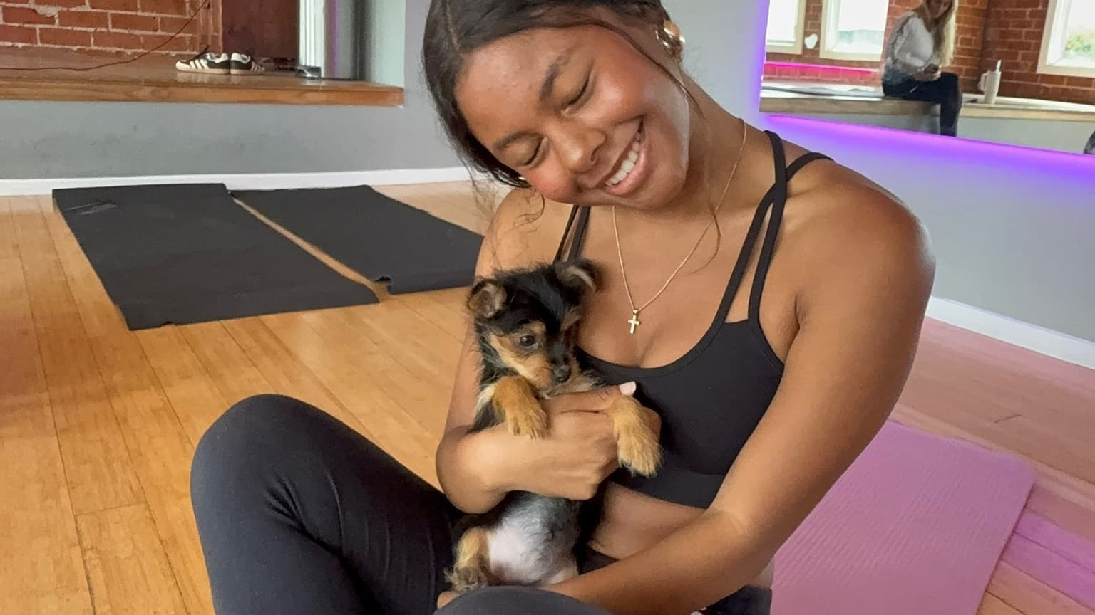 A guest relaxing with a puppy during a Puppy & Flow class in Los Angeles