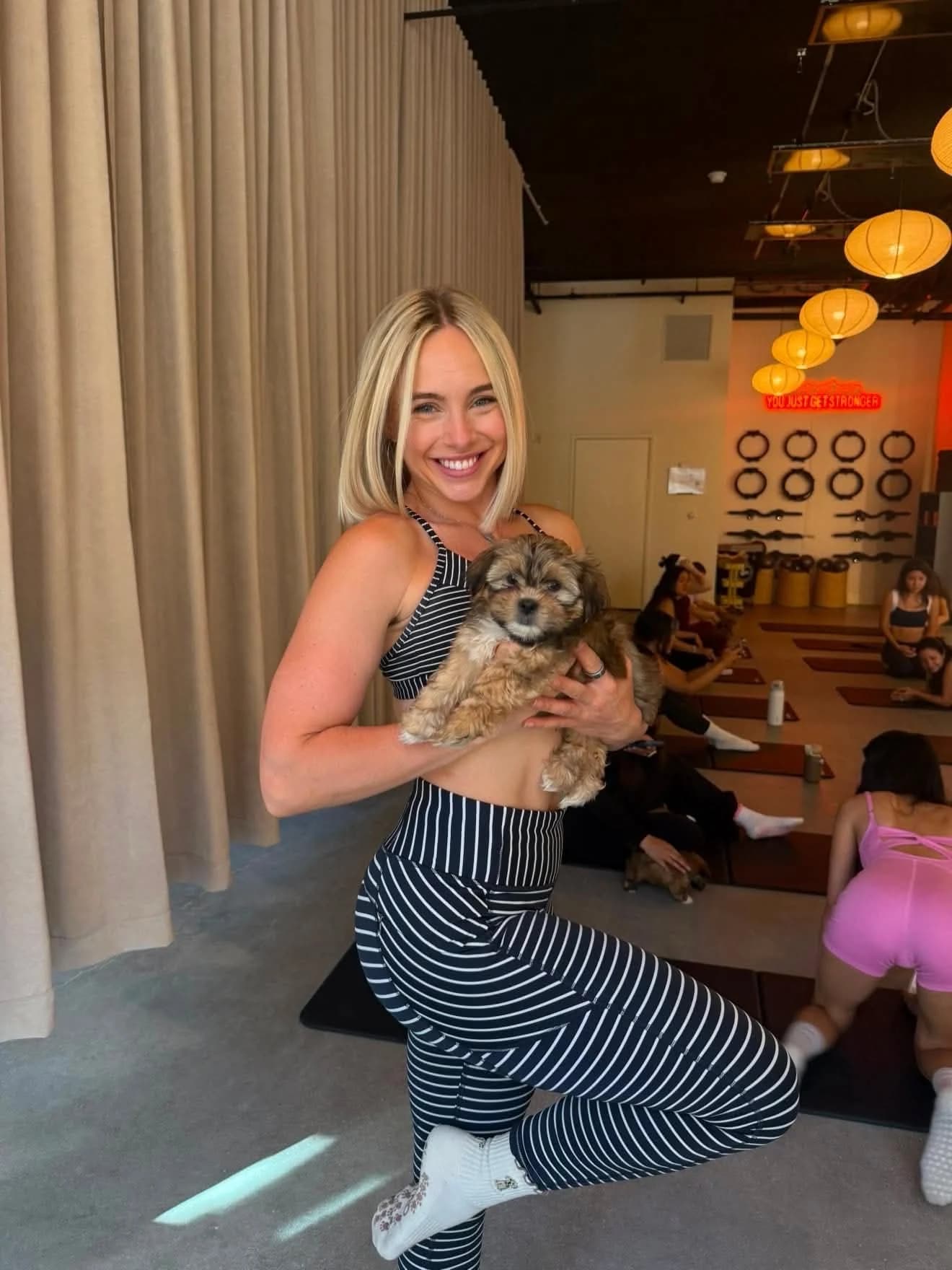 Guest holding a puppy inside the North Hollywood Pilates studio