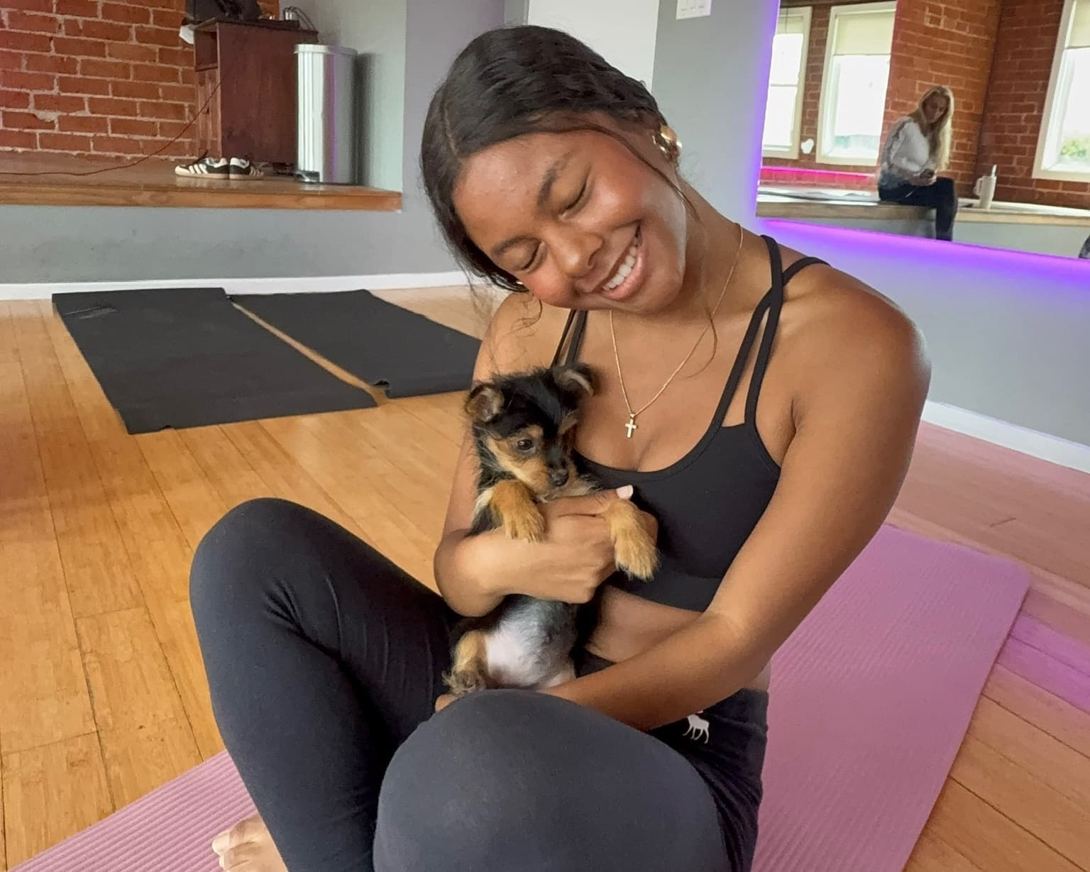 A guest sharing a calm, supervised moment with a puppy during class